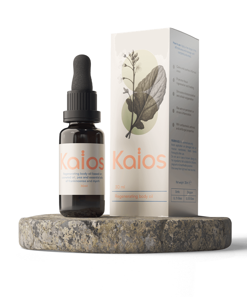 Packshot Kaïos Body Oil: flacone ambrato con etichetta “Kaïos” e scatola coordinata con grafica botanica, in posa su base di pietra
