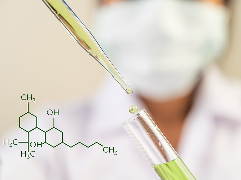 Ricercatore con pipetta e provetta contenente CBD sintetico in laboratorio, formula chimica in sovrimpressione.