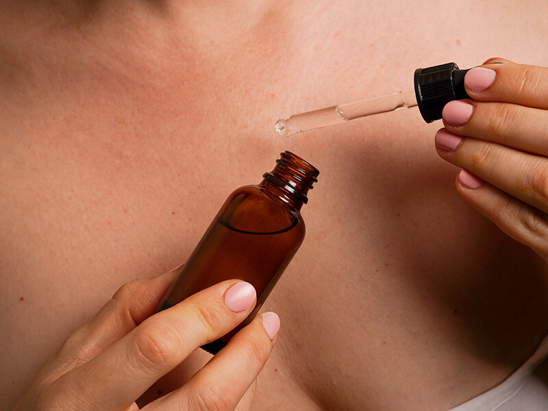 Applicazione di olio corpo con contagocce: gesto quotidiano per idratare e rassodare la pelle con oli funzionali