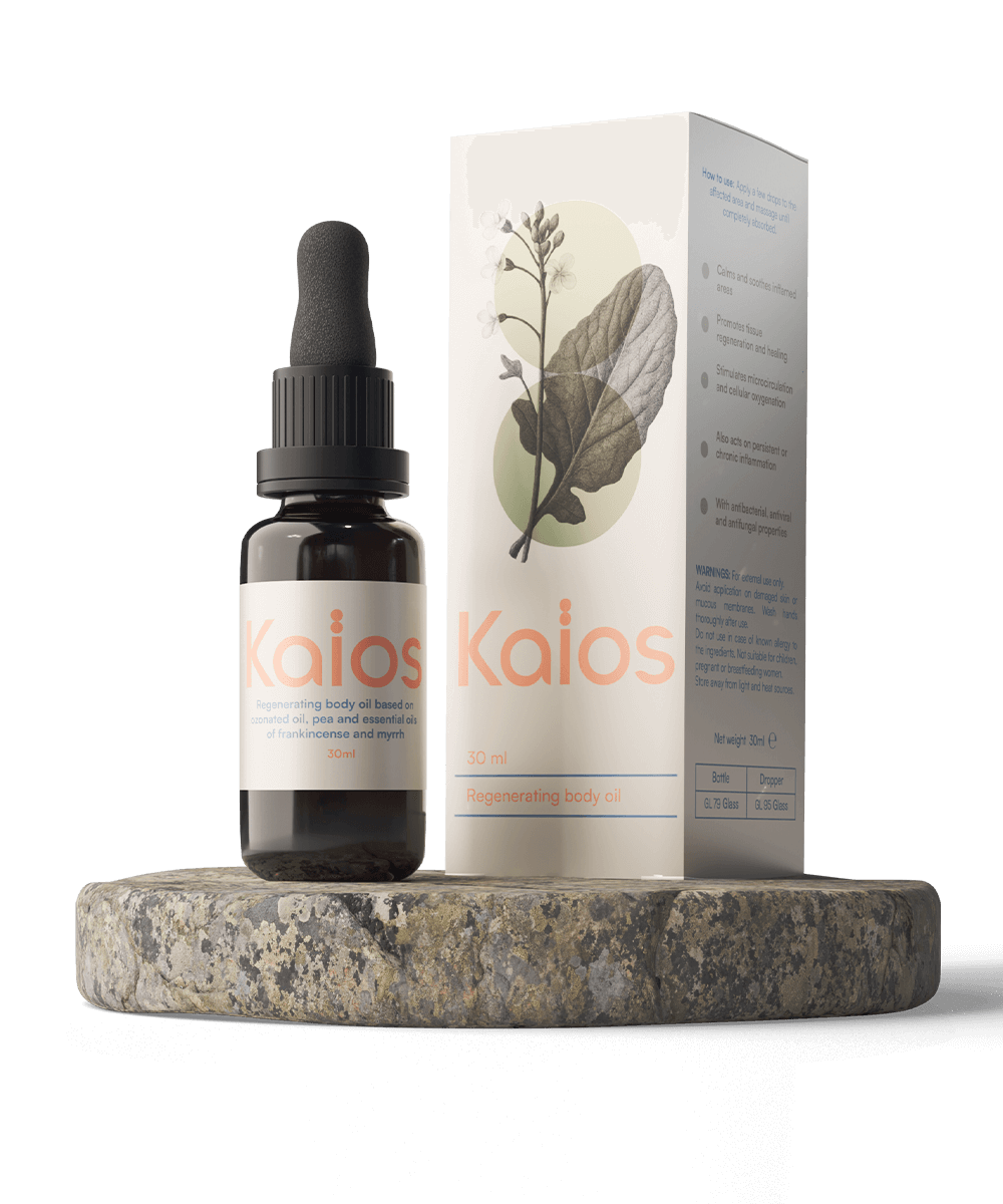 Packshot Kaïos Body Oil: flacone ambrato con etichetta “Kaïos” e scatola coordinata con grafica botanica, in posa su base di pietra