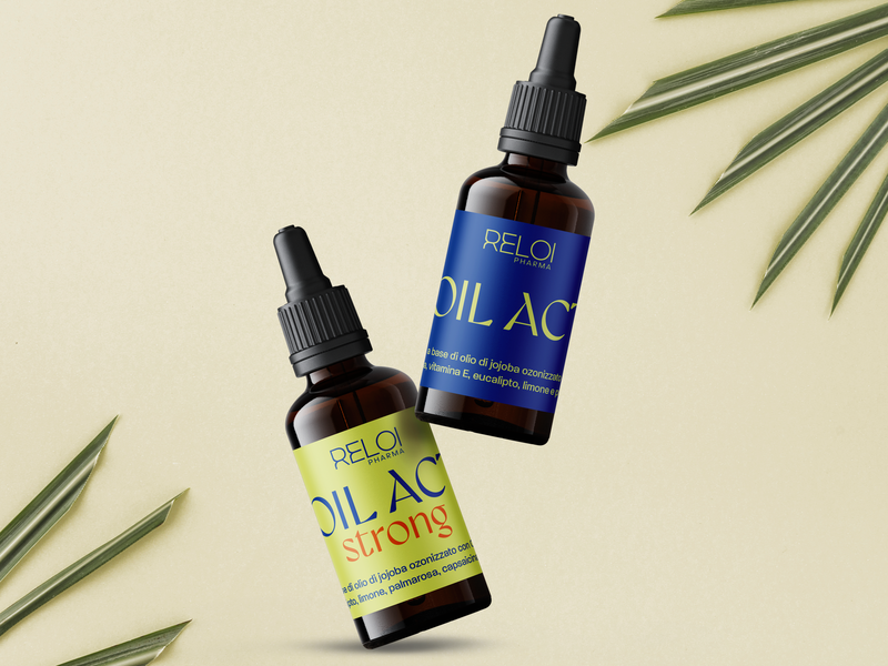Flaconi di olio corpo Reloil Active e Reloil Active Strong su sfondo wellness con foglie verdi.