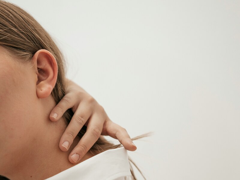 Donna che si massaggia la cervicale per alleviare tensione e rigidità al collo